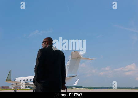 Afrikanische amerikanische Geschäftsmann auf Flughafen Rollfeld stehend Stockfoto