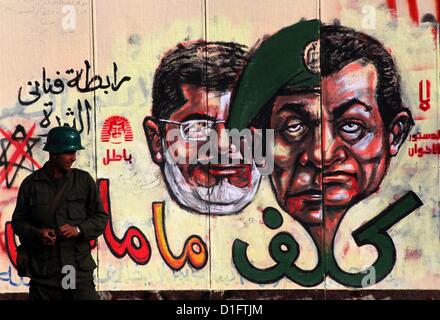 19. Dezember 2012 - Kairo, Kairo, Ägypten - Republikanischen Garde Soldat steht Wache am Präsidentenpalast und Anti-Mursi Graffiti ist auf den Palast Wand hinter ihm in Kairo, 18. Dezember 2012 zu sehen. Ägyptens Opposition inszeniert Rallyes quer durch das Land am Dienstag gegen den Entwurf einer Verfassung Referendum zu protestieren, nachdem des Justizministeriums des Landes eine Sonde Vorwürfen des weit verbreiteten Unregelmäßigkeiten während der Samstag den ersten Wahlgang am Dokument bestellt (Credit-Bild: © Ashraf Amra/APA Images/ZUMAPRESS.com) Stockfoto