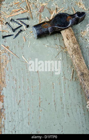 Alte Vintage Hammer und schwarze Nägel auf grünem rustikalen hölzernen Hintergrund mit Textfreiraum, DIY-Konzept Stockfoto