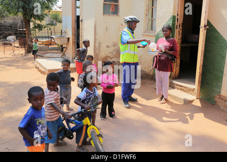 Freiwilliger Leoni´s Care Center NGO in Tsumeb/Namibia bringt Suppe in den Armen einer Gemeinde Stockfoto