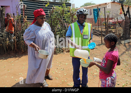 Freiwilliger Leoni´s Care Center NGO in Tsumeb/Namibia bringt Suppe in den Armen einer Gemeinde Stockfoto