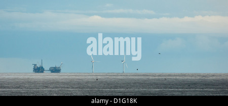 Ein Öl / gas-Rig und Offshore-Windmühlen auf den fernen Horizont. Stockfoto