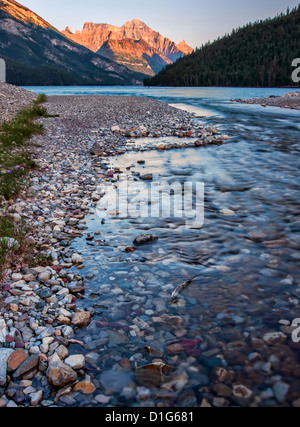 Die bunten Felsen in dieser Fluss führen das Auge auf die schöne Orange beleuchteten Berg im Hintergrund. Stockfoto
