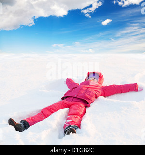 wenig rot nettes Mädchen im Winter Oberbekleidung mit Haube liegt im Schnee und lächelt Stockfoto