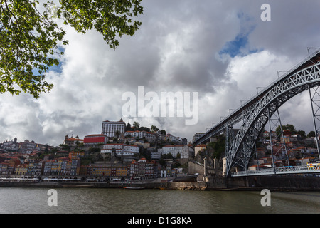 Stadtgebäude und D Luis Brücke über den Fluss Douro entlang der Uferpromenade in Porto, Portugal Stockfoto