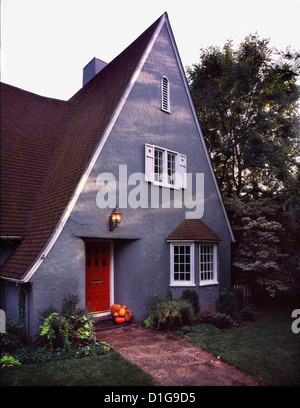 Außen grau Cottage Stilhaus mit Spitzdach und rote Tür Stockfoto