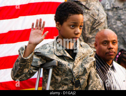 Khalil Quarles, 10, erhebt seine Rechte Hand, während seine ehrenamtlichen Eintragung in der Army Reserve wie sein Vater, Uhren 20. Dezember 2012 in Baltimore, Maryland. Khalil Traum, Soldat zu sein ist aber eine seltene Form von Krebs im Endstadium leidet. Soldaten mit dem 200. Militärpolizei Befehl zeigte sich bei Khalil Haus und hielt eine Zeremonie der Eintragung sowie eine einheitliche, Dogtags, eine Flagge und eine Fahrt in ein gepanzertes Humvee. Stockfoto