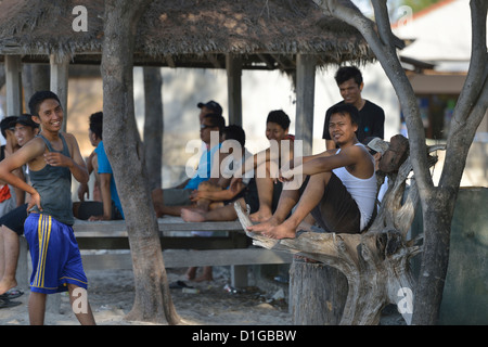 Indonesische Jungs warten, bis die Sonne untergeht, so dass sie ein Fußballspiel in Gili Trawangan beginnen werden; Lombok, Indonesien. Stockfoto