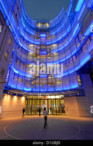 Eingang zum Broadcasting House bei Nacht mit blauer Flutbeleuchtung auf dem neuen Ostflügel-Anbau und BBC-Logo Langham Place London England UK Stockfoto
