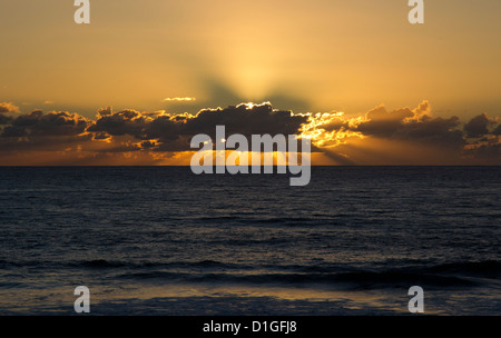 Sonnenstrahlen hinter niedrigen Wolken Stockfoto