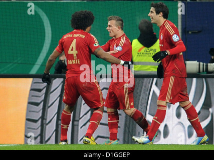 Münchens Xherdan Shaqiri (M) feiert sein 2: 0-Tor mit Javier Martinez (R) und Dante (L) bei den DFB-Pokal Runde 16 Spiel zwischen FC Augsburg und FC Bayern München in der SGL Arena in Augsburg, Deutschland, 18. Dezember 2012. Foto: Tobias Hase Stockfoto