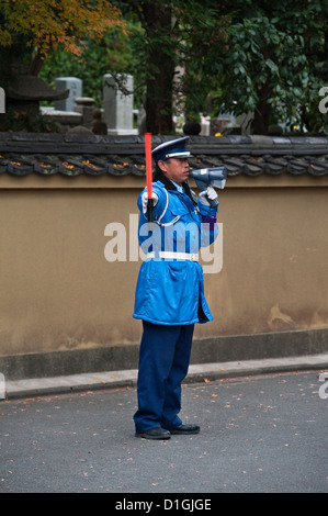 Ein Sicherheitsbeamter, der die riesigen Touristenmassen lenkt, die kommen, um das berühmte Herbstlaub in Tofuku-ji, Kyoto, Japan, zu sehen Stockfoto