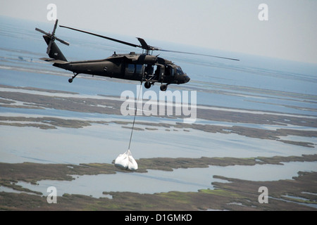 Ein Louisiana National Guard black Hawk Hubschrauber trägt 5000-Pfund Sandsäcke im Bemühen um die Deepwater Horizon von beweglichen Öl befleckt Wasser vorenthalten zu näher an der Küste von Louisiana 9. Mai 2012 in Lafourche Parish, Louisiana Stockfoto