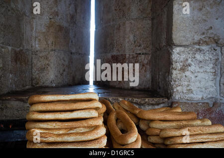 Kaek, lokale Sesam Bagels, bedeckt von einem Wagen im Inneren der Struktur im Sonnenlicht schlüpft durch, was einmal als eine dünne Scharte diente Jaffa-Tor verkauft. Jerusalem, Israel. 21. Dezember 2012.  Ein kalten, windigen und regnerischen Winter-Sonnenwende Morgen am Jaffa-Tor als einheimische und Touristen suchen Zuflucht vor dem Regen anstatt Armageddon am Ende des Maya-Kalenders. Stockfoto