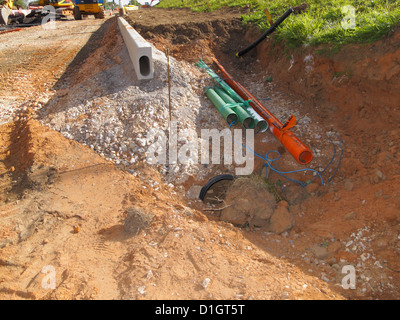 Neue Aco hohlen Entwässerung Kerb Bordsteine und Dienstleistungen Kommunikation Dienstprogramme Rohr Kunststoff Schächte in einen Graben Straßenbau Website UK Stockfoto