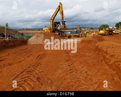 Baggerlader Bagger Verbreitung Straße Stein Sub base harten Kern auf Autobahnbau Website UK Stockfoto