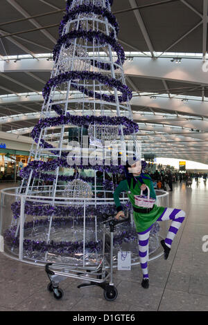 21. Dezember 2012.  T5 Flughafen Heathrow, London. Ein Schauspieler verkleidet in einem Elf-Kostüm, Reisende, was erwartet wurde, zu den verkehrsreichsten Tag für Weihnachten Reisen zu unterhalten. © Danny Callcut Stockfoto