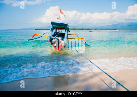 Gili Meno, einem traditionellen indonesischen Boot auf Gili Meno mit Gili Air und Lombok im Hintergrund, Gili-Inseln, Indonesien Stockfoto