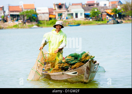 Mann aus seinem Boot auf den alten Hafen von Hoi an, Vietnam, Indochina, Südostasien, Asien Stockfoto