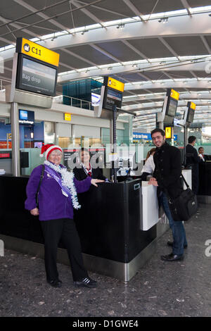 21. Dezember 2012.  T5 Flughafen Heathrow, London, was erwartet wurde, zu den verkehrsreichsten Tag für Weihnachten reisen. Phyllis Rabbetts, Freiwilliger am Flughafen, Witze mit Check-in Personal und Passagiere. © Danny Callcut Stockfoto