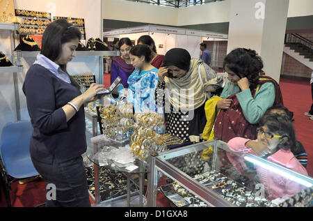 Besucher nehmen reges Interesse an den Schmuck in einem Stall während der Expo India 2012, organisiert von Karachi Industrie-und Handelskammer und Industrie (KCCI) und Verband der indischen Export Organisation (an), im Expo-Center in Karachi am Freitag, 21. Dezember 2012 statt. Stockfoto