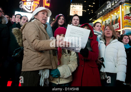 New York, NY - 21 Dezember 2012 über 500 Menschen erfüllt die rote Schritte auf dem Times Square willkommen Yoko Ono, Witwe des verstorbenen John Lennon, um Frieden von Lied Lennons "Imagine" mehrere hundert mehr versammelten sich in der Mall der Duffy Square zum Mitsingen zu feiern.  Zeitgleich mit der Wintersonnenwende zusammen, war das Lied Führung durch Thomas McCarger, Dirigent und Sänger, und unter der Schirmherrschaft von Make Music New York. Stockfoto