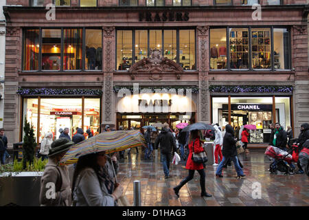 Buchanan Street, Glasgow, Schottland, Großbritannien, Samstag, 22nd. Dezember 2012. Weihnachtseinkäufe machen ihren Weg durch ein geschäftiges Stadtzentrum im Regen mit Sonnenschirmen neben dem House of Fraser Kaufhaus Stockfoto