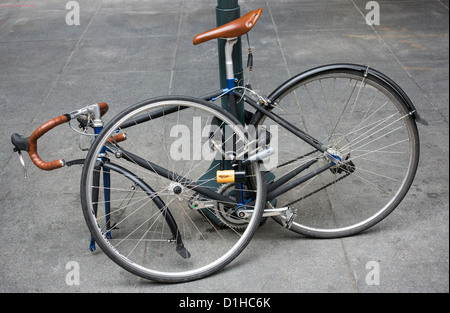 Ein Rennrad angekettet an eine Stelle ausserhalb ein Bürogebäude in Midtown New York City Stockfoto