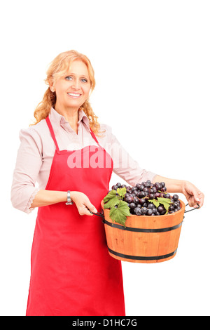 Eine weibliche Winzer hält einen Korb voller Weintrauben isoliert auf weißem Hintergrund Stockfoto