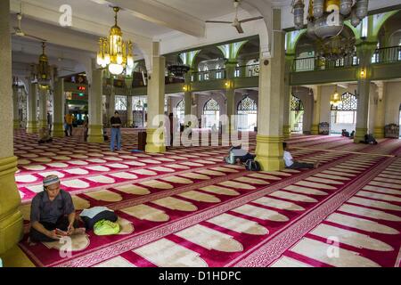 22. Dezember 2012 - Singapur, Singapur - beten Männer in der Hauptgebetshalle in der Sultan-Moschee in Singapur. Die Sultansmoschee steht im Mittelpunkt des historischen Kampong Glam-Bereichs von Singapur. Auch bekannt als Masjid Sultan, hieß es für Sultan Hussein Shah. Die Moschee wurde ursprünglich in den 1820er Jahren gebaut. Die ursprüngliche Struktur wurde 1924 das heutige Gebäude weichen die 1928 fertiggestellt wurde abgerissen. Die Moschee hat großen Bedeutung für die muslimische Gemeinschaft und gilt als die Nationalmoschee von Singapur. 1975 wurde zum Nationaldenkmal erklärt. (Kredit-Bild: © Jack Stockfoto