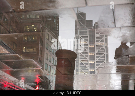 Reflexion der Heron-Tower in Pflaster Pfütze an einem regnerischen Tag in der City of London Stockfoto