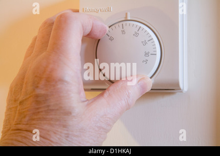 Schließen Sie herauf Rentner drehen Zentralheizung Thermostat zu sparen Stromkosten Stockfoto