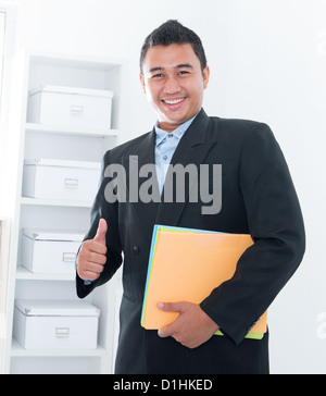 Daumen Sie hoch südostasiatischen executive stehen im Büro Stockfoto