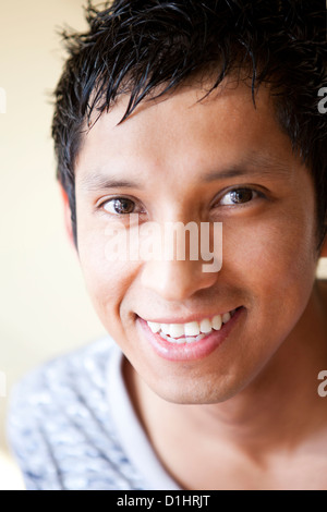 Ein junger Latino-Mann in seiner Mitte der zwanziger Jahre hat ein strahlendes Lächeln und fröhliche Haltung. Stockfoto