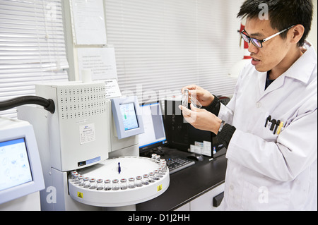 Ein Labor-Mitarbeiter prüft ergibt sich aus einem Reagenzglas Rührwerk Stockfoto