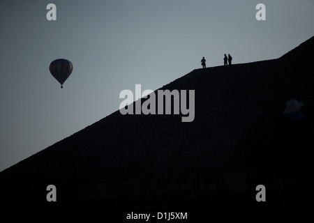 Ein Heißluftballon fliegt in den Himmel, wie Touristen auf der Oberseite der Pyramide der Sonne in den Ruinen von Teotihuacan Fuß Stockfoto