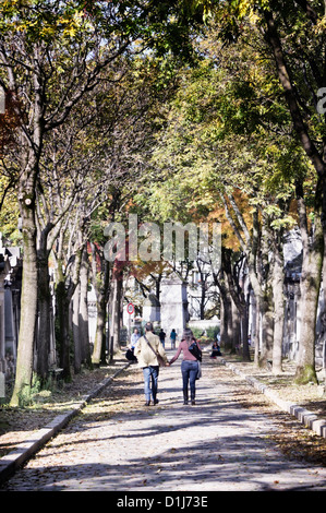 Paris, Frankreich: Paar hand in hand gehen am Friedhof Père Lachaise (Cimetière du Père-Lachaise) im Herbst Stockfoto