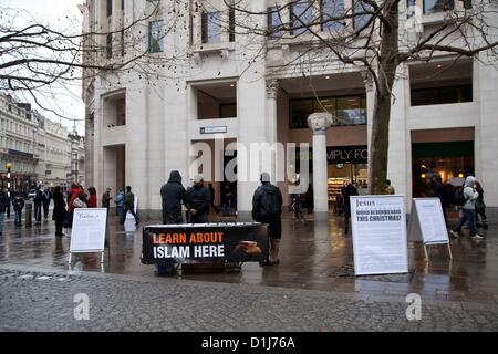 London, UK. 24. Dezember 2012 Gruppe von radikalen Muslime versammeln sich außerhalb St. Pauls Cathedral, wo sie Stände und verteilt Flugblätter mit der Absicht, Passanten des Islam zu informieren.  Zum nahe gelegenen Polizeioffiziere gab es verschiedene Beschwerden von den Leuten, die Schlange in der Nähe um St. Pauls Cathedral geben, wo sie einen Dienst teilnahmen. Stockfoto