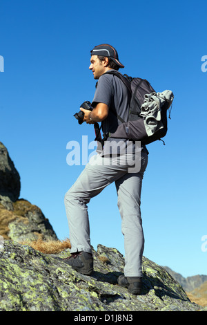 Junge Touristen fotografieren im Freien von der Spitze der Berge Stockfoto