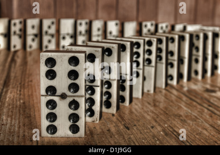 Reihen von aufgereiht altes Elfenbein und Ebenholz Bronze angehefteten stehende Domino blockiert Stücke auf viktorianischen Kiefer Tisch Holzplatte hinter Stockfoto