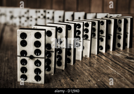 Reihen von aufgereiht altes Elfenbein und Ebenholz Bronze angehefteten stehende Domino blockiert Stücke auf viktorianischen Kiefer Tisch Holzplatte hinter Stockfoto