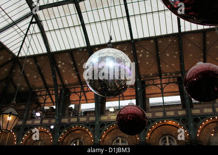 Große Disco-Kugel hängt von der Decke von Covent Garden, London zu Weihnachten mit anderen riesigen Kugeln Stockfoto