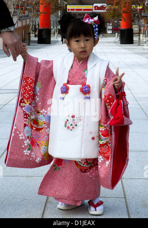 Kleine japanische Mädchen in traditionellen Kimono gekleidet auf den Fushimi Inari Tempelbesuch für das Shichi-Go-San (sieben, drei, fünf)-festival Stockfoto