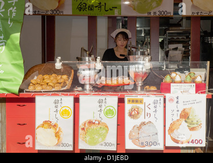 Frau-Anbieter verkaufen Snacks in einer Straße, die hinauf zum Kiyomizudera Tempel in Kyoto Stockfoto