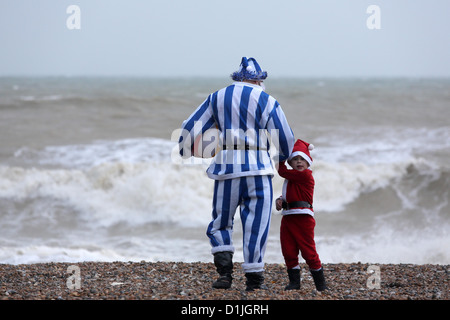 Das jährliche Weihnachtstag schwimmen in Brighton ist abgesagt wegen schlechtem Wetter, verlassen die schick gekleideten Schwimmer am Strand Stockfoto