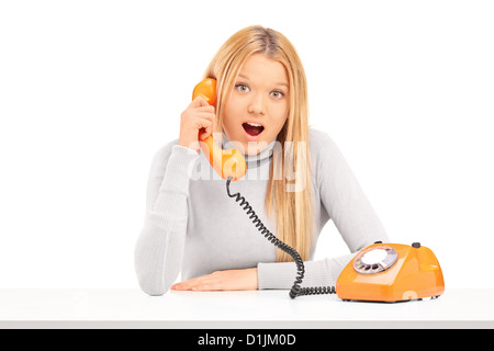 Junge Frau am Telefon isoliert auf weißem Hintergrund aufgeregt Stockfoto