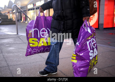 Brighton Großbritannien – Käufer kommen mit Taschen voller Schnäppchen aus dem Boxing Day Sale bei Next in Brighton Stockfoto