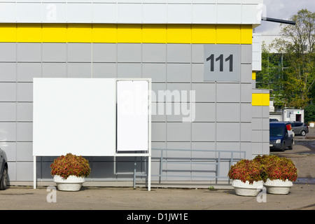 Der Eingang in die Stadt bezahlte Parkplätze 111 Anzahl in der Nähe einen Supermarkt. Massenproduktion leere Equipm, Plakate und Blumen Stockfoto