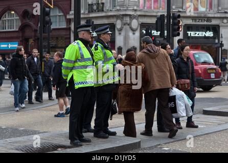 London, UK. 26. Dezember 2012 zwei Polizisten patrouillieren die Gegend um den Nike-Store auf der Oxford Street, die die Szene eines gewalttätigen Angriffs letztes Jahr am zweiten Weihnachtstag war. Diensthabenden patrouillieren im belebtesten Einkaufsstraßen Londons in diesem Jahr als Folge der Vorjahre Vorfälle gab es mehr Polizisten. Stockfoto