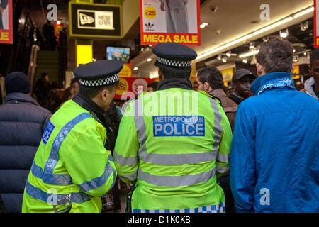 London, UK. 26. Dezember 2012 Polizisten befassen sich mit einem Vorfall in einem Sportgeschäft in der Oxford Street. Aufgrund der zwei Messerstechereien letztes Jahr auf der Oxford Street gab mehr Polizisten im Dienst patrouillieren im belebtesten Einkaufsstraßen Londons. Stockfoto